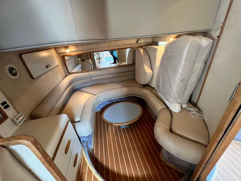 Slide: The Image of Interior of 1993 Sea Ray 440 Sundancer with beige seating and wooden flooring. - 26
