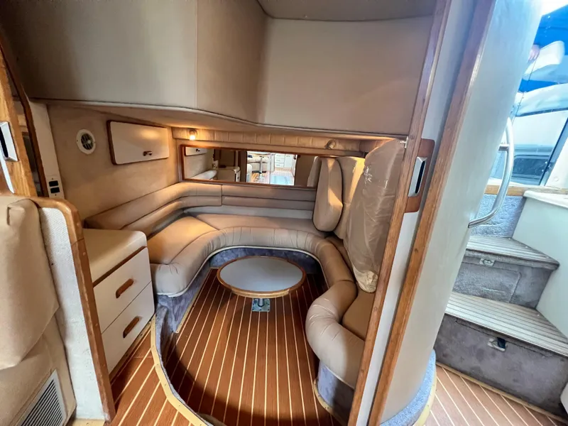 Slide: The Image of 1993 Sea Ray 440 Sundancer interior with curved seating and wooden flooring. - 28