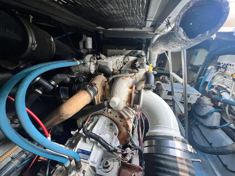 Slide: The Image of Engine compartment of a 1993 Sea Ray 440 Sundancer boat with visible hoses and components. - 37