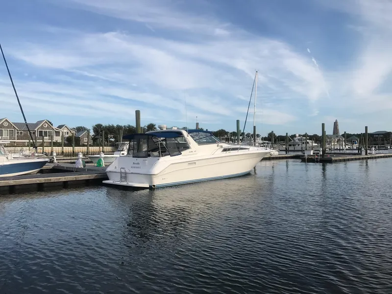 Slide: The Image of 1993 Sea Ray 440 Sundancer docked at a marina on a sunny day. - 4