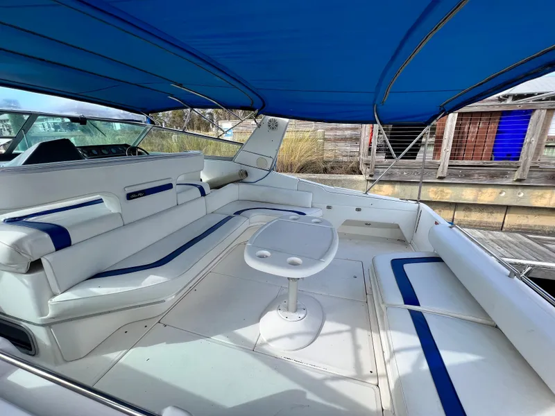 Slide: The Image of 1993 Sea Ray 440 Sundancer boat with spacious seating and blue canopy. - 7
