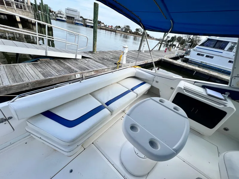 Slide: The Image of 1993 Sea Ray 440 Sundancer boat interior with white and blue seating at a marina. - 8