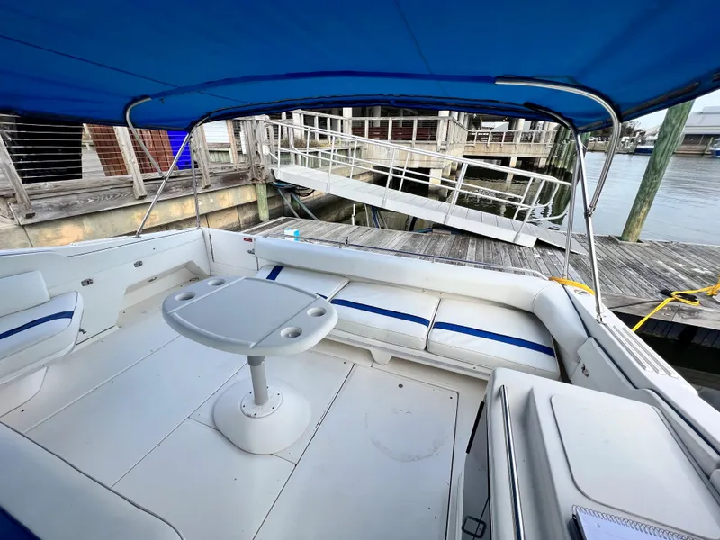 Slide: The Image of 1993 Sea Ray 440 Sundancer boat interior with blue canopy at dock. - 9