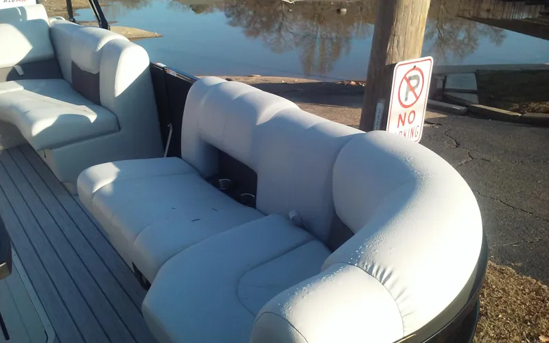 Slide: The Image of 2023 SunCatcher Fusion 324 SS boat with plush seating near a waterfront. - 12