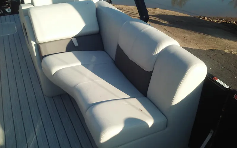 Slide: The Image of 2023 SunCatcher Fusion 324 SS boat seating, featuring white and gray cushioned upholstery. - 13