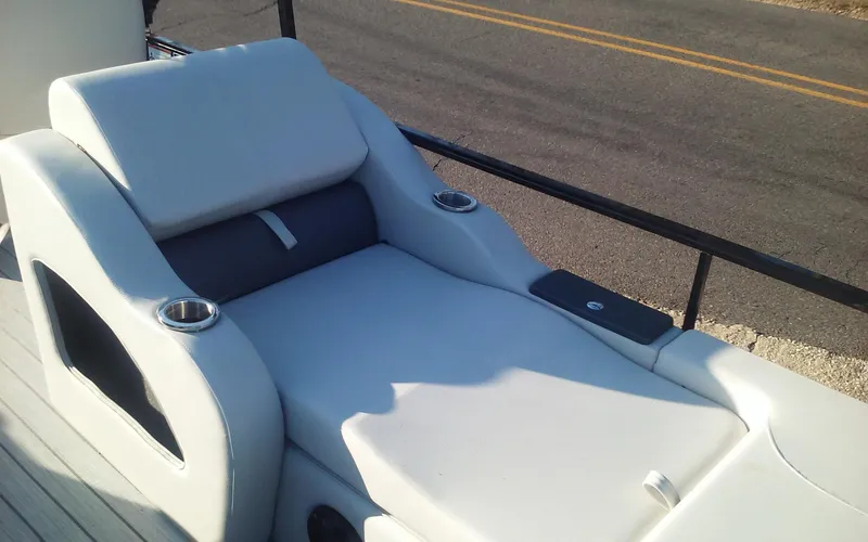 Slide: The Image of 2023 SunCatcher Fusion 324 SS boat lounge seat with cup holders, outdoor setting. - 18