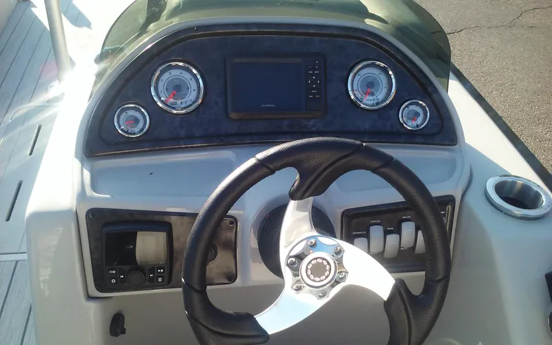 Slide: The Image of 2023 SunCatcher Fusion 324 SS boat dashboard with steering wheel and gauges. - 22