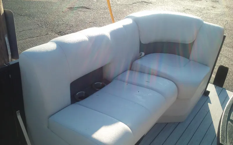 Slide: The Image of 2023 SunCatcher Fusion 324 SS boat seating with cup holders, outdoor setting. - 25