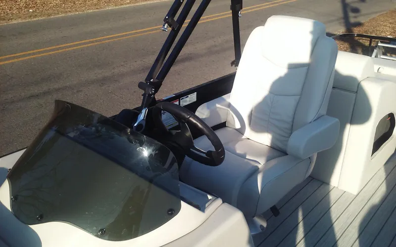 Slide: The Image of 2023 SunCatcher Fusion 324 SS boat interior with steering wheel and white captain's chair. - 26