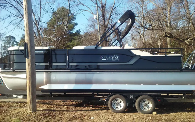 Slide: The Image of 2023 SunCatcher Fusion 324 SS pontoon boat on trailer, parked outdoors. - 8