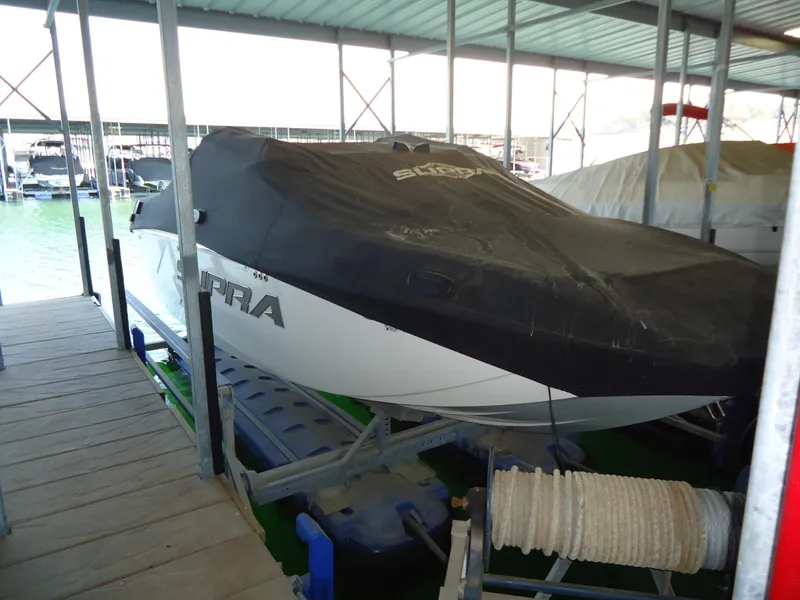 Slide: The Image of 2018 Supra SL boat covered and docked in a marina. - 11