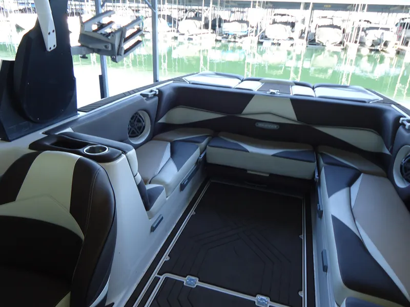 Slide: The Image of Interior of a 2018 Supra SL boat with cushioned seating and cup holders. - 18