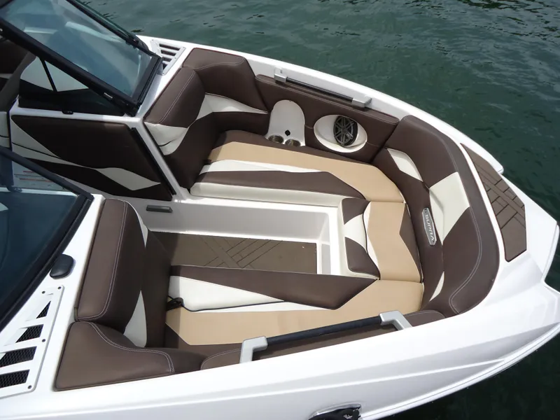 Slide: The Image of 2018 Supra SL boat interior with brown and white cushioned seating. - 23