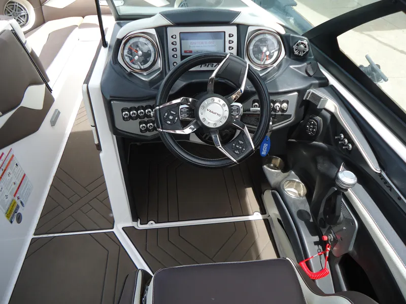 Slide: The Image of 2018 Supra SL boat dashboard with steering wheel, control panel, and navigation screen. - 26