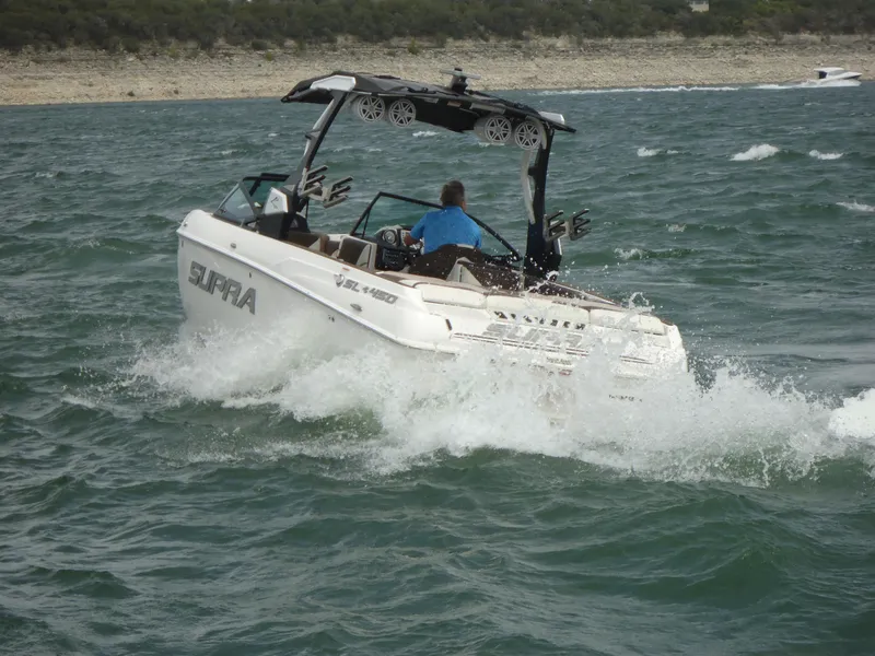 Slide: The Image of 2018 Supra SL boat cruising on a lake. - 3