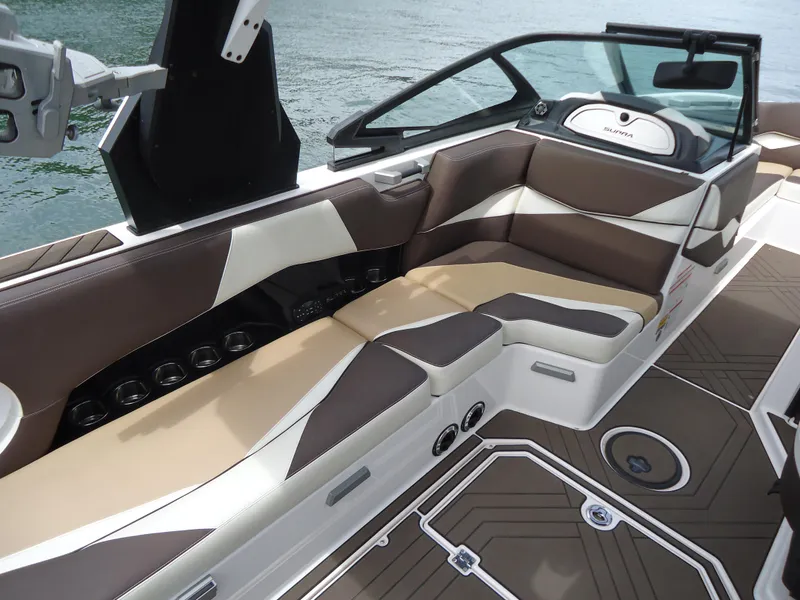 Slide: The Image of 2018 Supra SL boat interior with brown and beige seating, modern design, and lake view. - 30