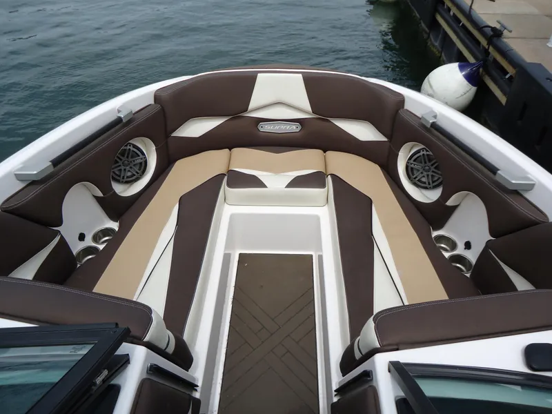 Slide: The Image of 2018 Supra SL boat interior with brown and beige seating, speakers, and cup holders. - 32