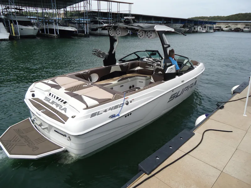 Slide: The Image of 2018 Supra SL boat docked at a marina, rear view. - 4
