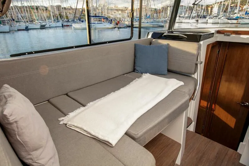 Slide: The Image of Interior seating area of 2024 Jeanneau NC 895 Sport boat with marina view. - 11