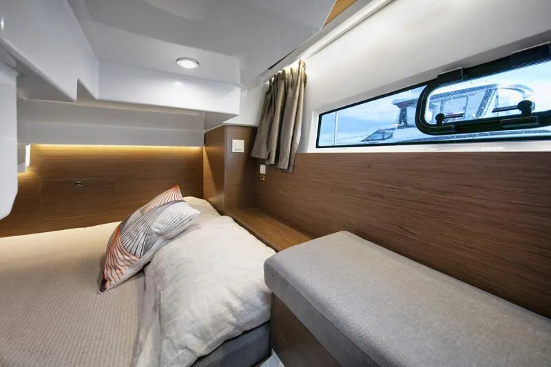Slide: The Image of 2024 Jeanneau NC 895 Sport cabin interior with bed, window, and modern design. - 18