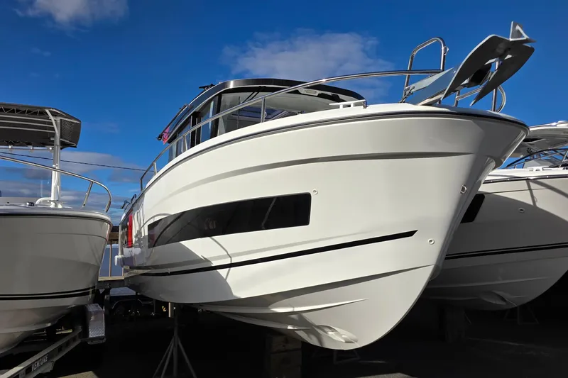 Slide: The Image of 2024 Jeanneau NC 895 Sport boat displayed under clear blue sky. - 26