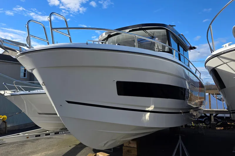 Slide: The Image of 2024 Jeanneau NC 895 Sport boat on display under a clear blue sky. - 28