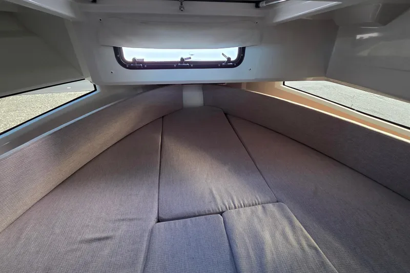 Slide: The Image of 2024 Jeanneau NC 895 Sport cabin interior with cozy bedding and window view. - 35
