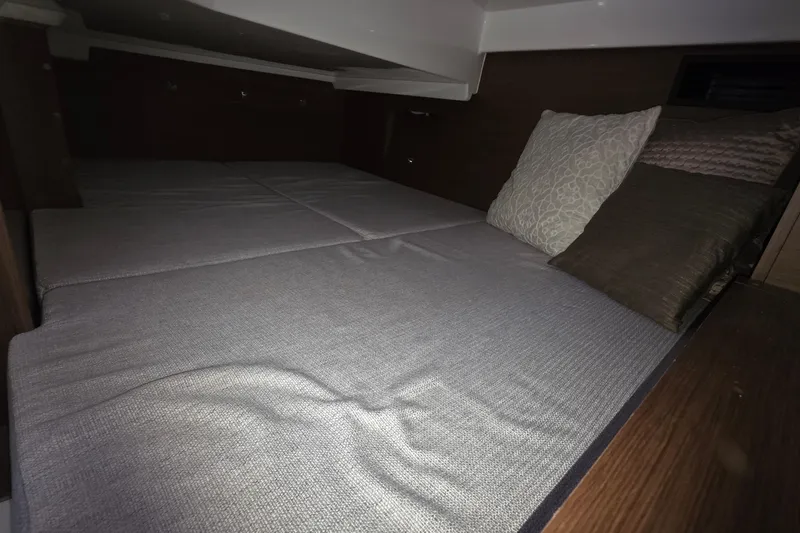 Slide: The Image of 2024 Jeanneau NC 895 Sport cabin interior with cozy bedding and pillows. - 42