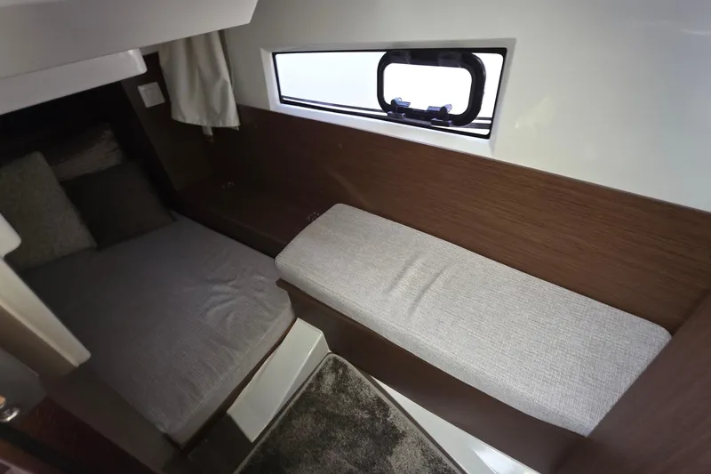 Slide: The Image of 2024 Jeanneau NC 895 Sport cabin interior with cozy seating and window view. - 43