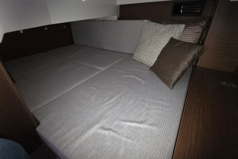 Slide: The Image of 2024 Jeanneau NC 895 Sport cabin interior with cozy bedding and cushions. - 44