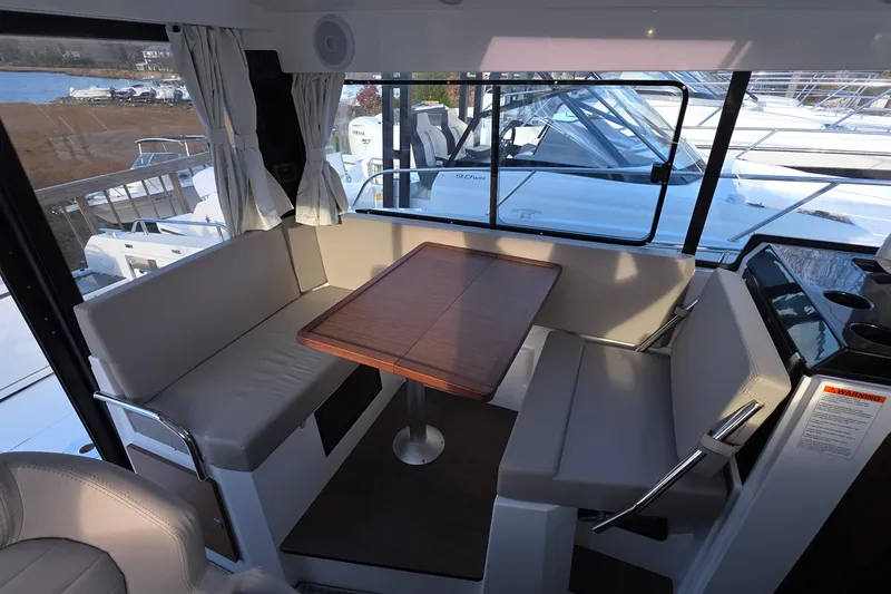 Slide: The Image of 2024 Jeanneau NC 895 Sport interior with cozy seating and wooden table. - 46