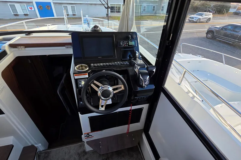 Slide: The Image of 2024 Jeanneau NC 895 Sport helm with steering wheel and navigation controls. - 51