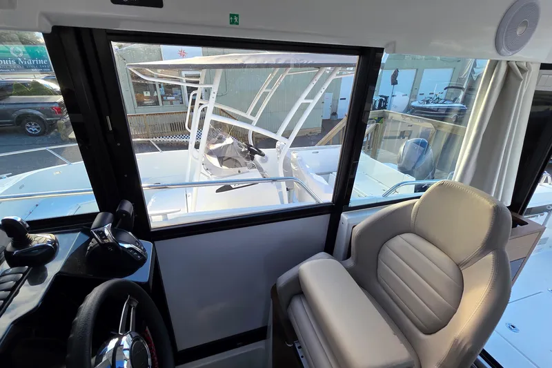 Slide: The Image of 2024 Jeanneau NC 895 Sport interior view with helm and seating area. - 52