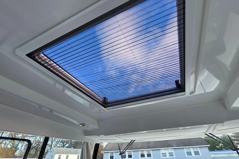 Slide: The Image of 2024 Jeanneau NC 895 Sport sunroof with blue sky view through blinds. - 60