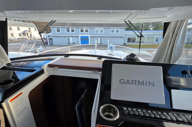 Slide: The Image of 2024 Jeanneau NC 895 Sport helm with Garmin navigation system and exterior view. - 62