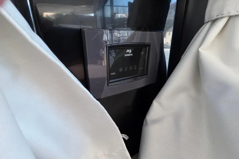 Slide: The Image of Control panel on 2024 Jeanneau NC 895 Sport boat, partially covered by curtains. - 63