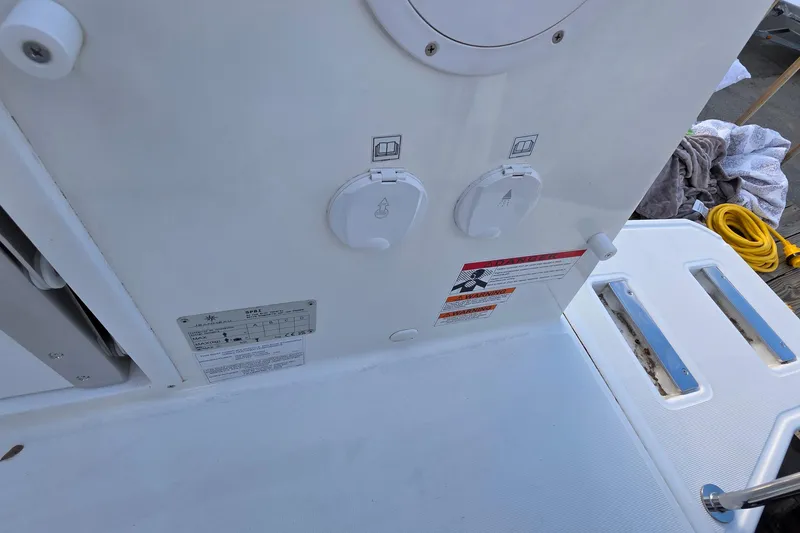 Slide: The Image of 2024 Jeanneau NC 895 Sport boat deck with utility connections and warning labels. - 66