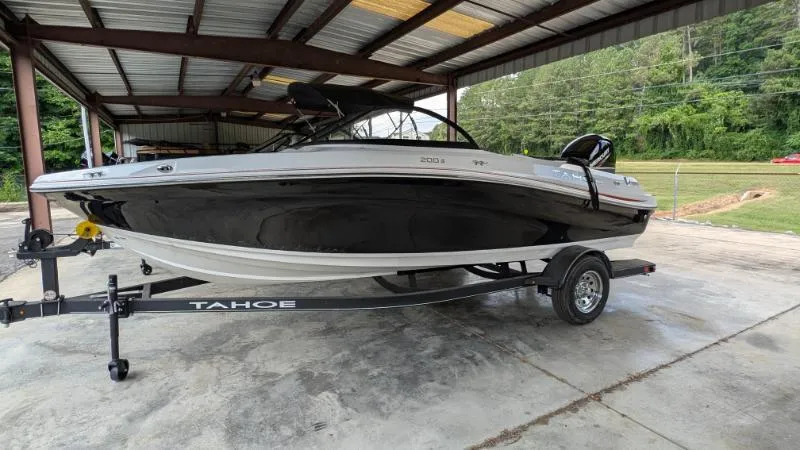 The Image of 2023 Tahoe 200 S boat on trailer under metal canopy. - 0