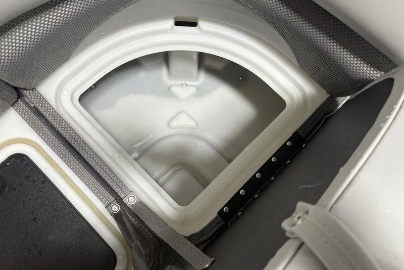 Slide: The Image of 2023 Regency 230 DL3 boat storage compartment with textured interior and secure straps. - 16