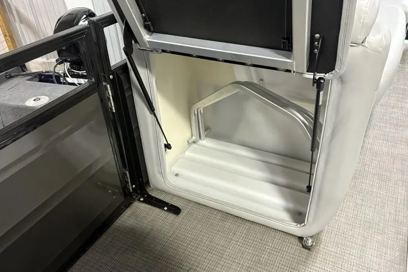 Slide: The Image of 2023 Regency 230 DL3 boat storage compartment with open hatch and hydraulic support. - 17