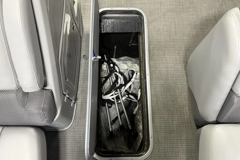 Slide: The Image of Open storage compartment in 2023 Regency 230 DL3 boat, showing interior contents. - 22