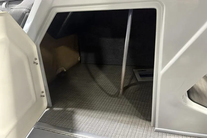 Slide: The Image of Open storage compartment in 2023 Regency 230 DL3 boat, featuring carpeted interior. - 27