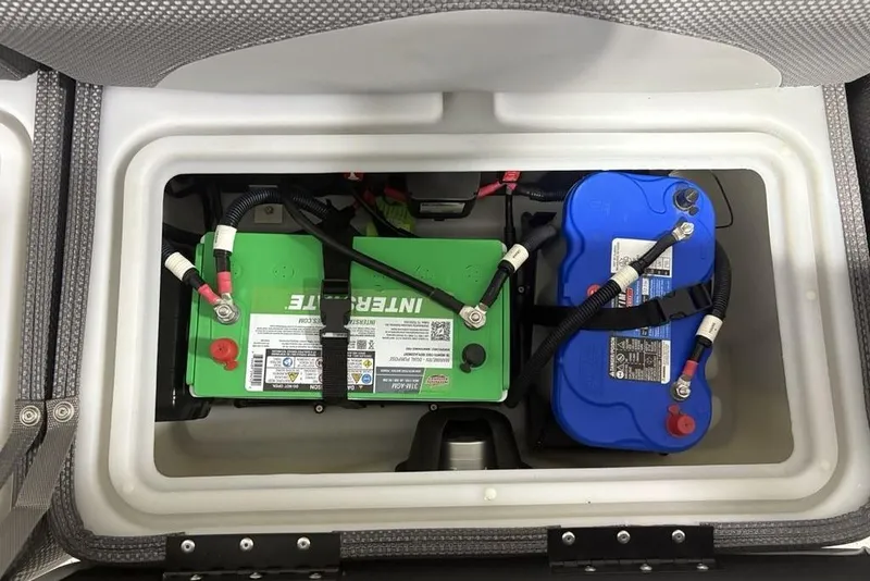 Slide: The Image of 2023 Regency 230 DL3 boat battery compartment with green and blue batteries. - 31