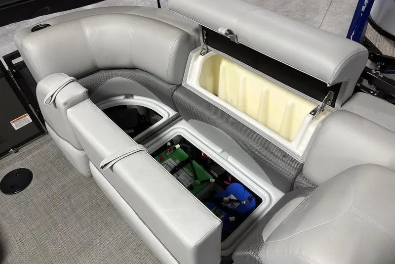 Slide: The Image of 2023 Regency 230 DL3 boat interior storage compartments with seating and battery access. - 32