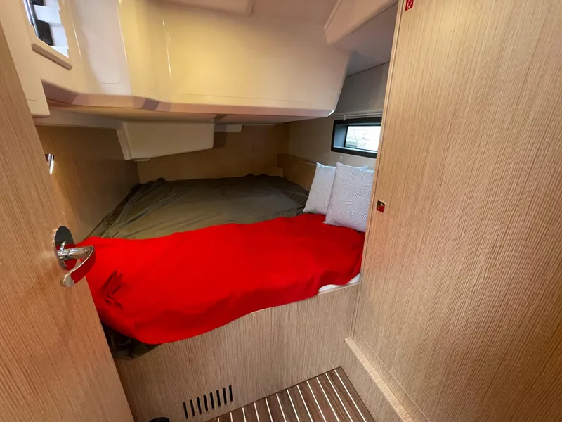 Slide: The Image of Cozy cabin interior of 2023 Bavaria C38 yacht with red blanket and pillows. - 23