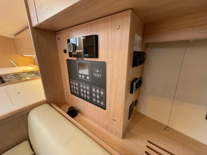 Slide: The Image of Control panel inside 2023 Bavaria C38 yacht, featuring modern wood finish and sleek design. - 27