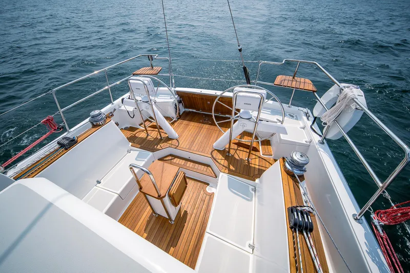 Slide: The Image of Modern Tartan 455 sailboat cockpit with dual steering wheels, teak flooring, and ocean backdrop. - 6