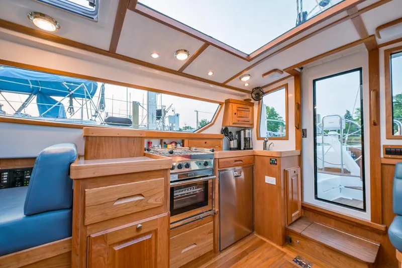 Slide: The Image of Interior of 2025 Tartan 455 sailboat with modern kitchen and wooden cabinetry. - 12