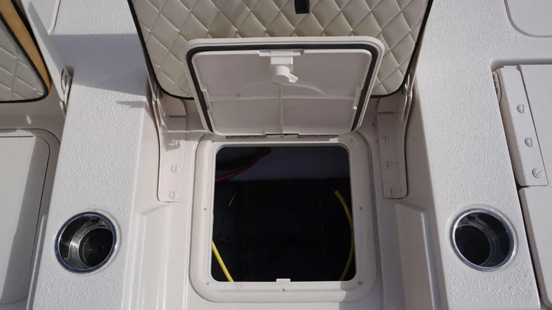 Slide: The Image of 2023 Carolina Skiff 24 Ultra Elite boat storage compartment with open hatch. - 10