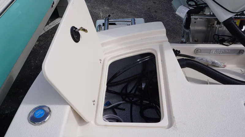 Slide: The Image of 2023 Carolina Skiff 24 Ultra Elite boat storage compartment with open hatch. - 11